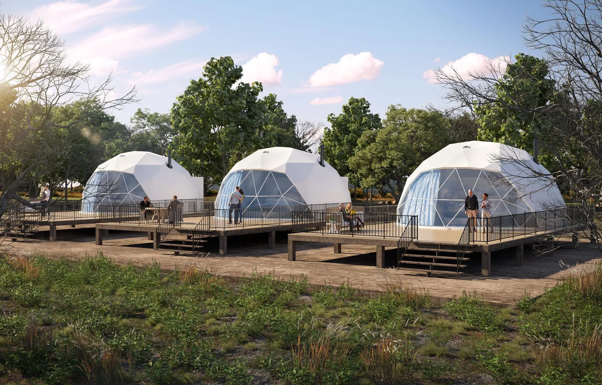 Three illuminated dome accommodations surrounded by trees